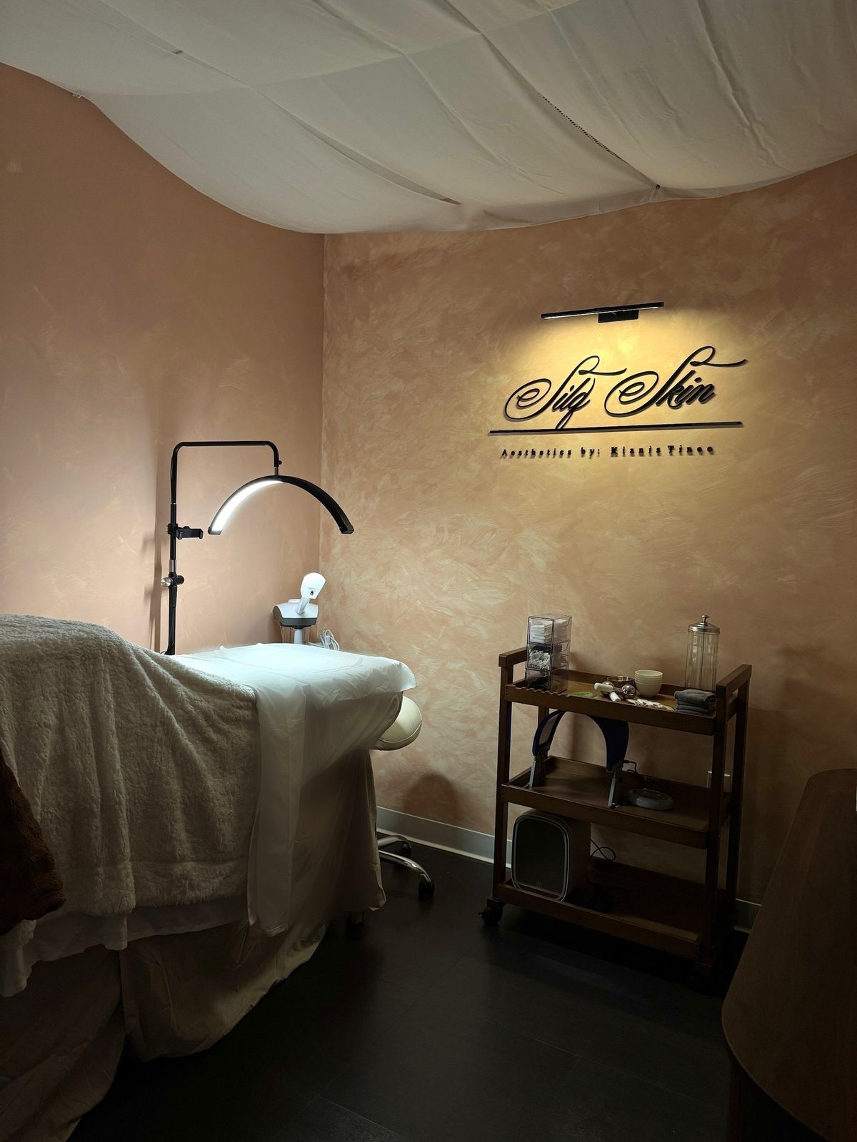 Treatment room with facial bed, lamp and Silq Skin sign