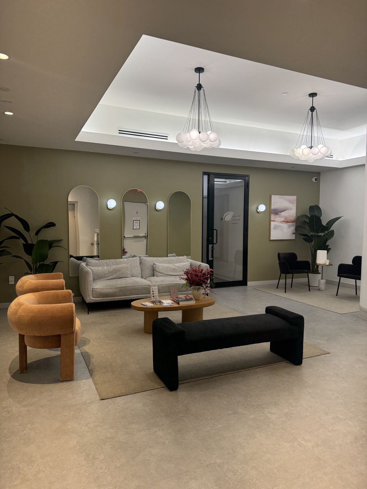 The client waiting area with a sofa, armchairs and pendant lights